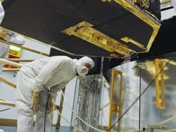 Astronaut john grunsfeld checks clearances on the bottom of the fine guidance sensor as it is being installed into the hubble mockup inside the goddard cleanroom. this sensor is also slated to be installed during servicing mission 4.