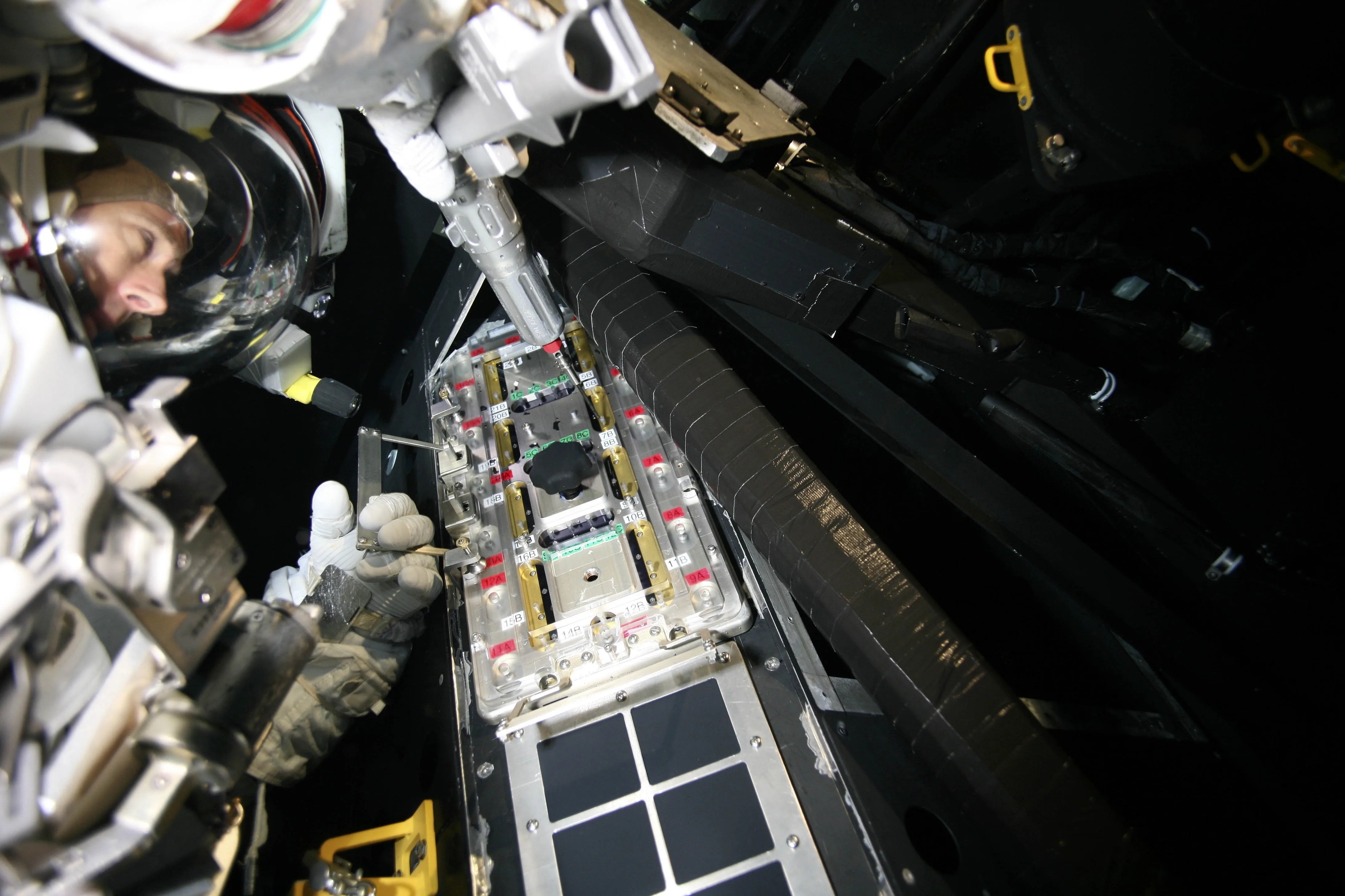 Astronaut Andrew Feustel practices installing the Fastener Capture Plate