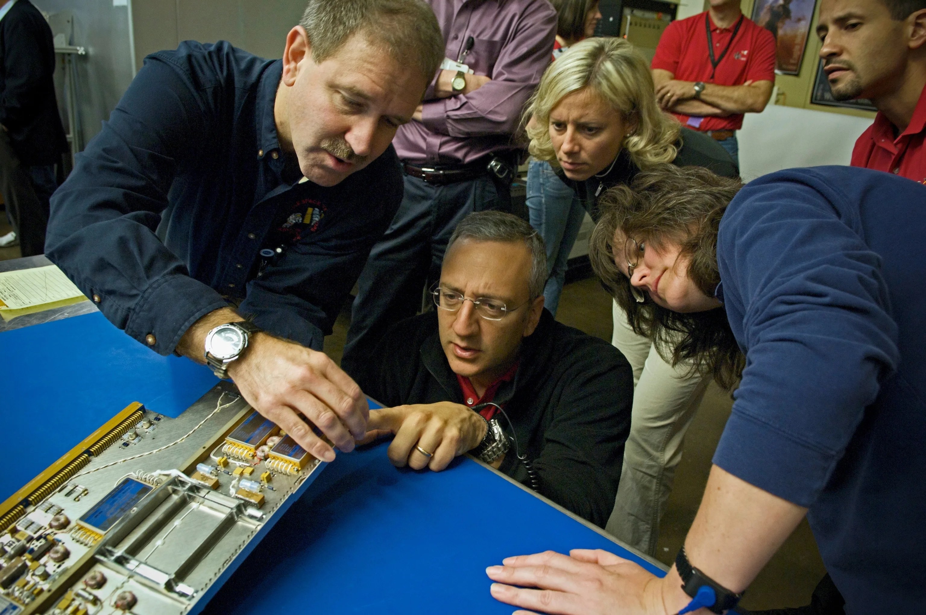 Astronauts John Grunsfeld (left) and Mike Massimino inspect position indicator decals on the STIS replacement printed circuit board