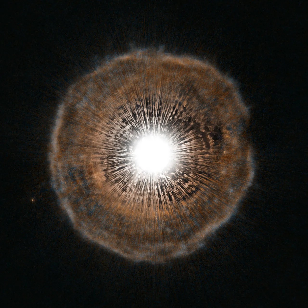 Starburst with radiating lines pushing a bubble of reddish haze out from an exploding star