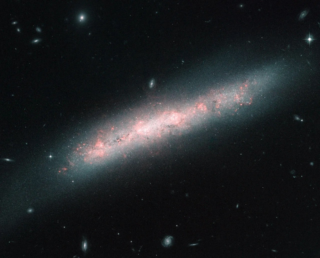 A diffuse edge-on disc galaxy with a heart of hot pink star-forming areas.
