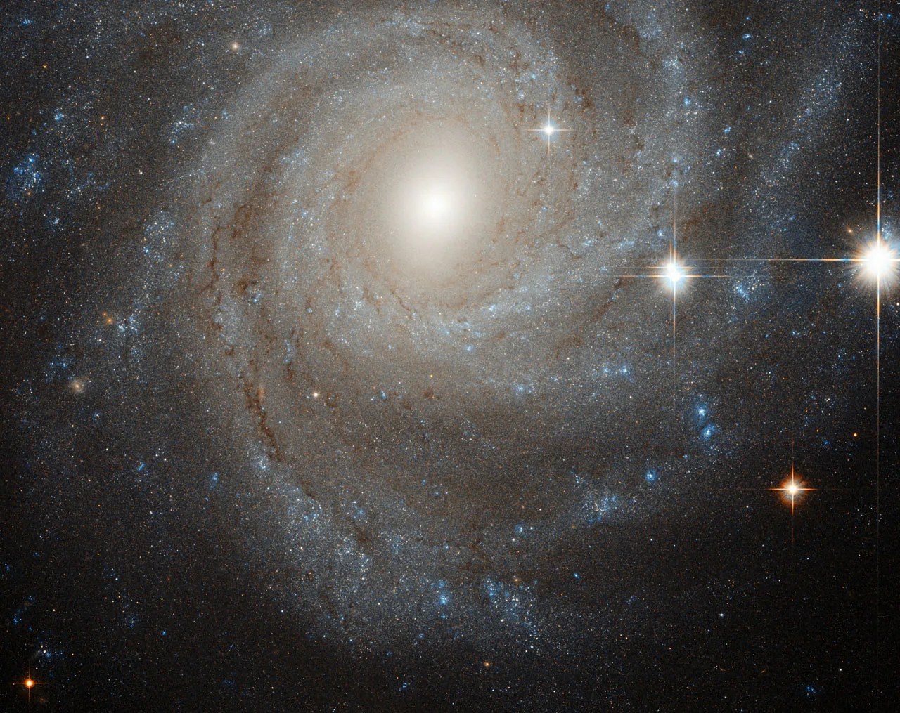 an off-center spiral galaxy, fringed by several nearby bright stars