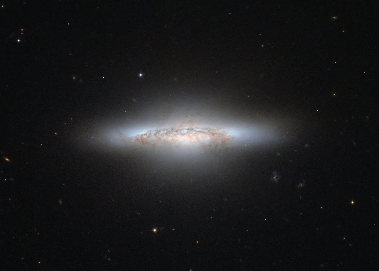 An aging galaxy, losing its spiral structure with orange and black streaks like a Hollywood explosion