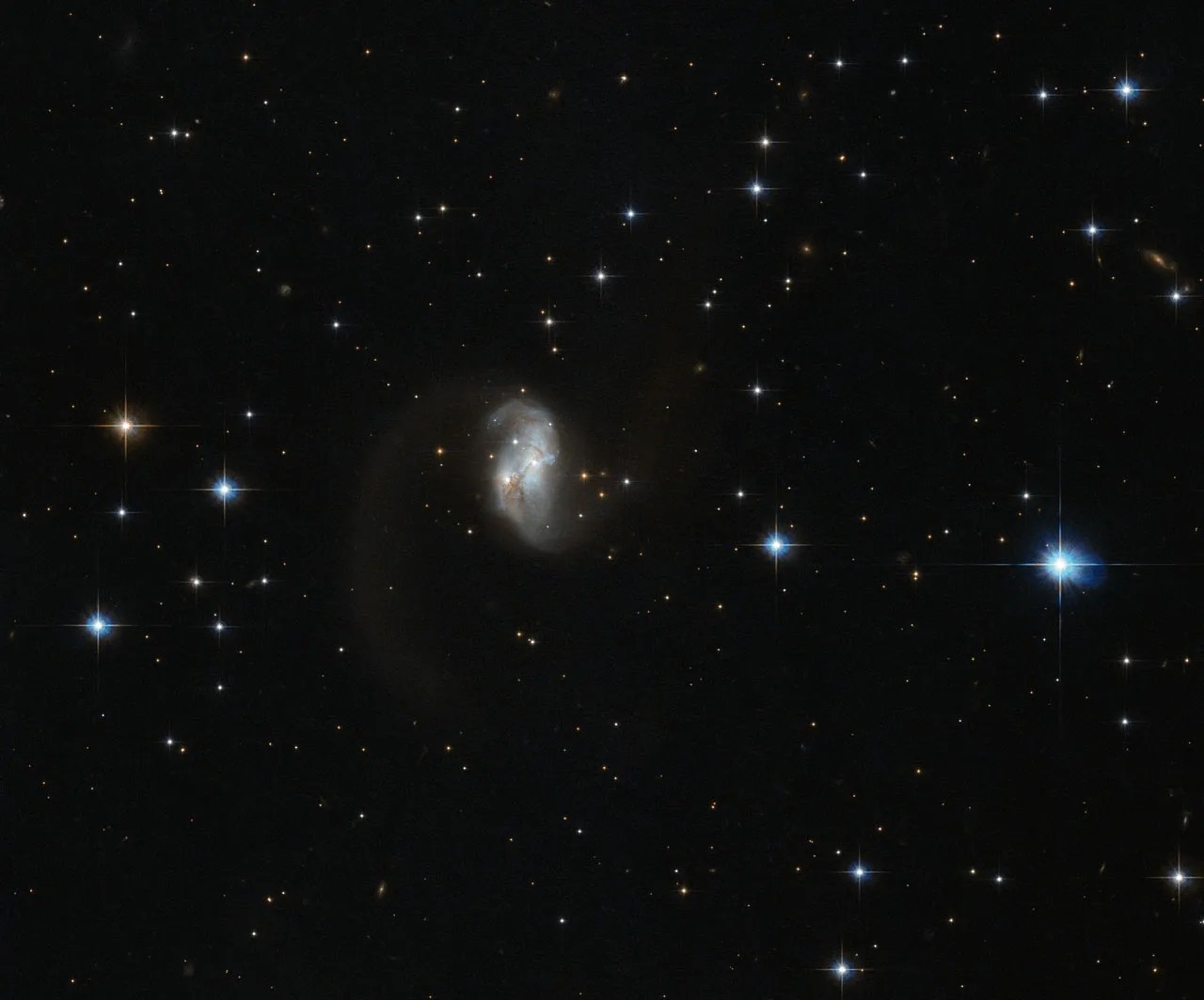 The central portion of this spiral galaxy is the only part visible, giving it an asymmetric form with a tail