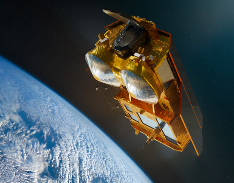 Image of large gold colored satellite in orbit above the earth