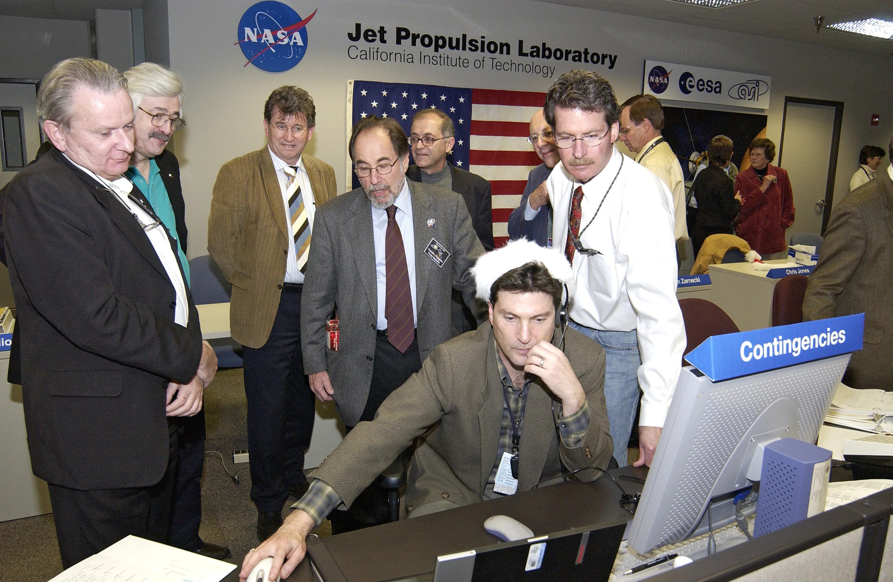 Group of men gathered at console.Credit: NASA/JPL-Caltech