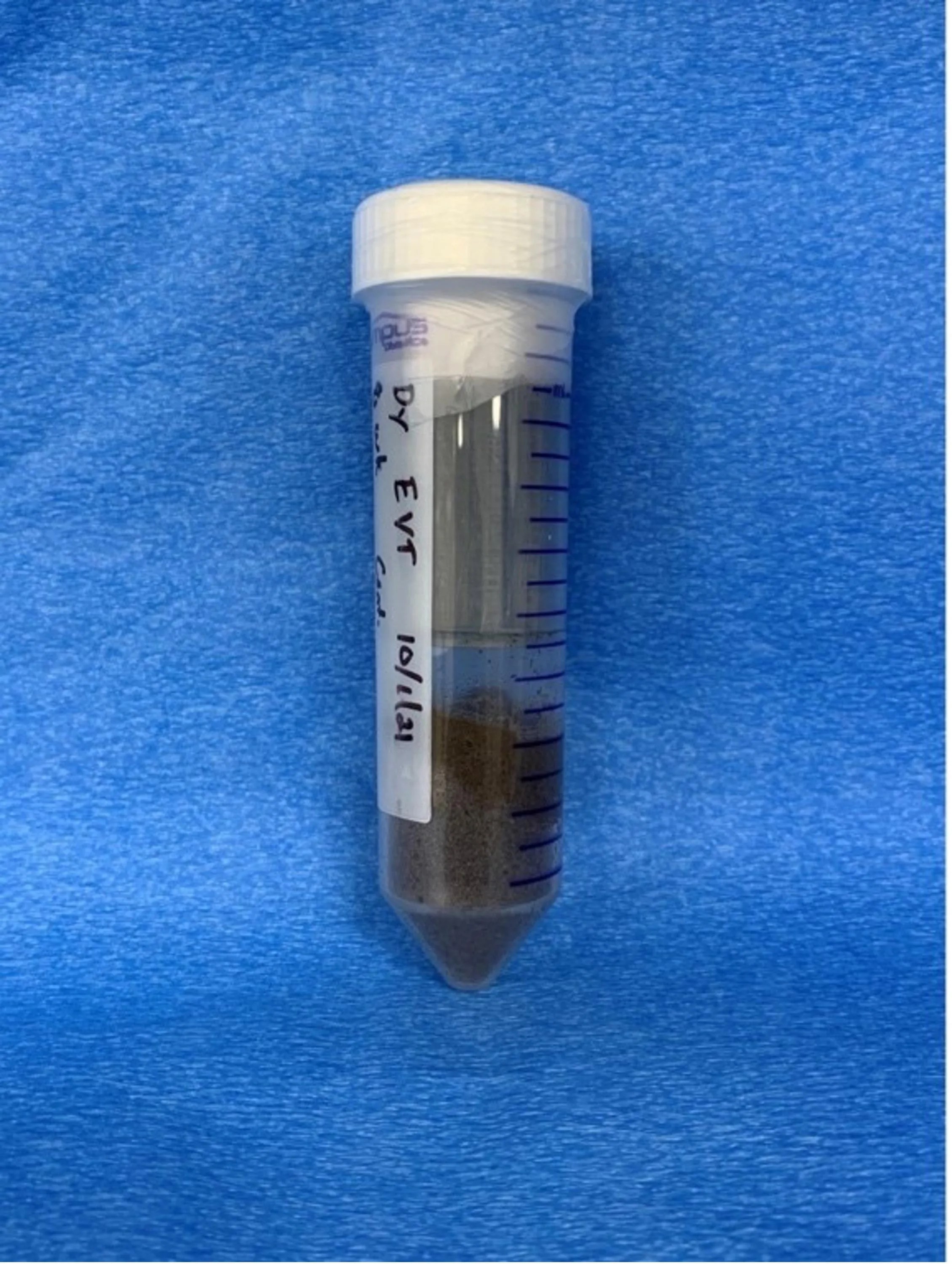 50 mL centrifuge tube with a white stopper at the top of the tube. The bottom 25% of the tube contains dark soil.