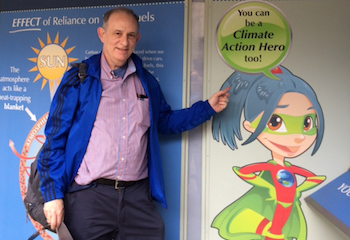 Jack Kaye standing in front of a sign that reads, You can be a Climate Action Hero too!